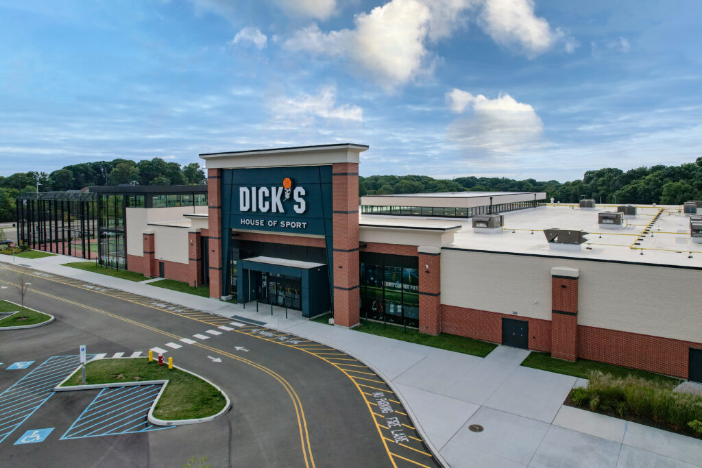 Aerial view of a Dick’s House of Sport store with a large parking lot and outdoor sports courts.