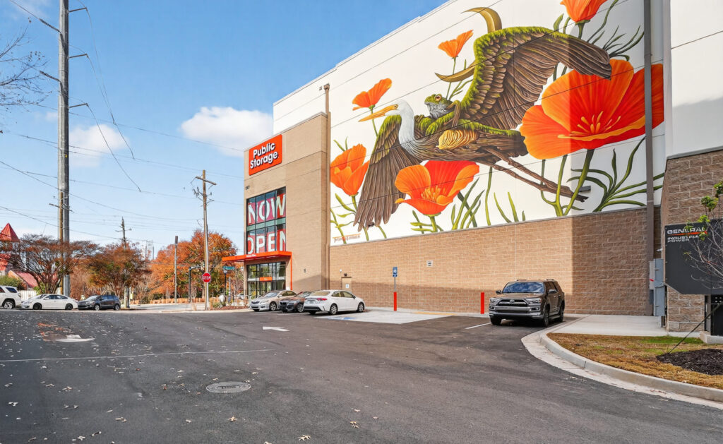 Public Storage facility with a large mural of a heron and poppies on the exterior wall.