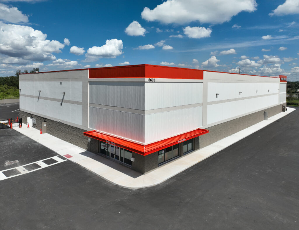 Aerial view of a Public Storage building with white walls, a red roofline, and an entrance labeled “Rental Office” at the corner.