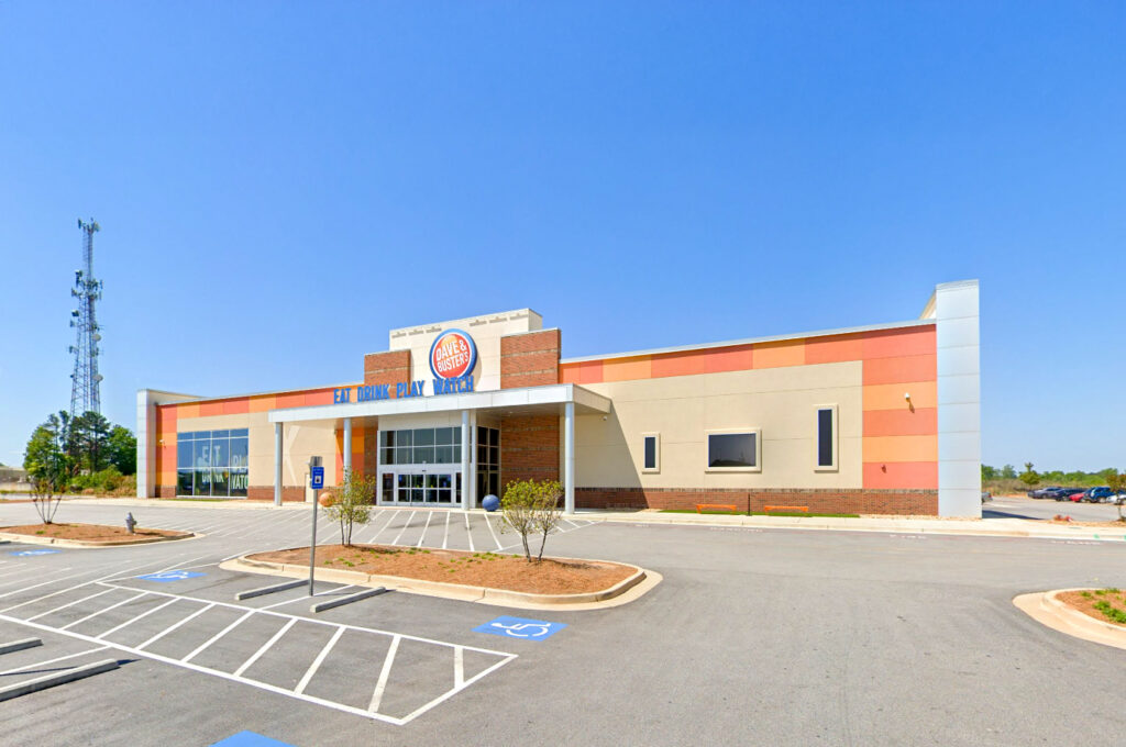 Dave & Buster’s restaurant exterior with a parking lot and blue sky.