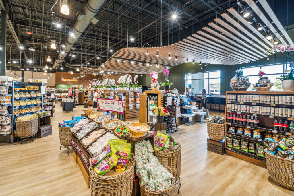 Interior of a specialty food market with baskets of candy and taffy in the foreground and shelves stocked with gourmet products throughout the store.