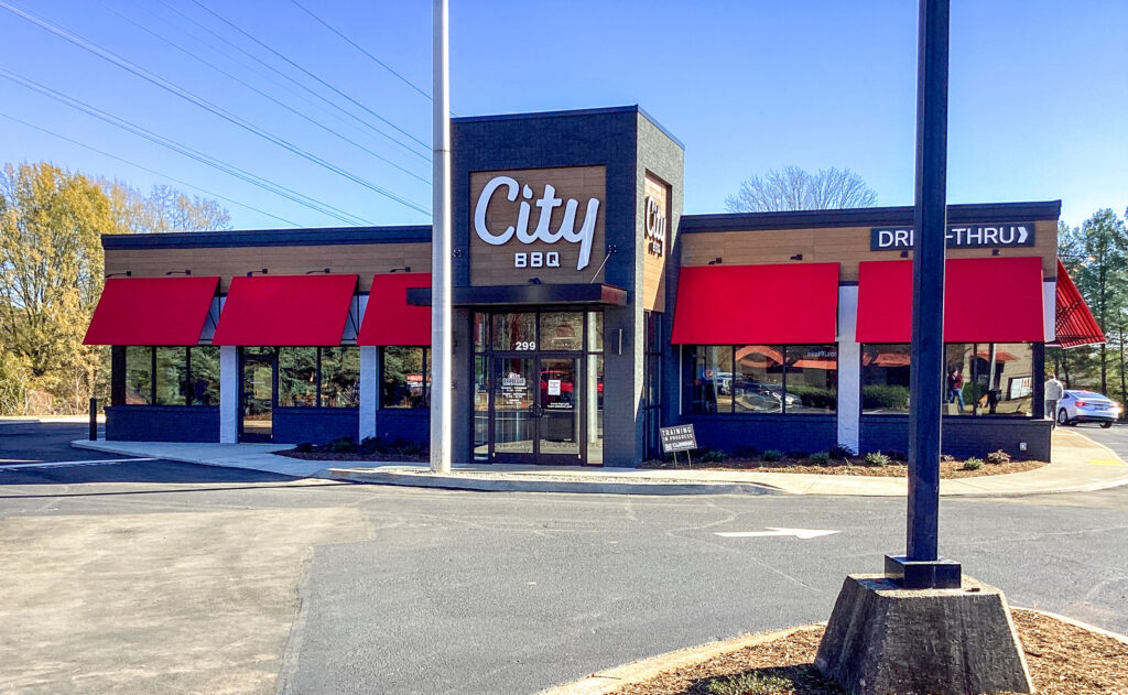 City BBQ restaurant building with red awnings and a drive-thru.