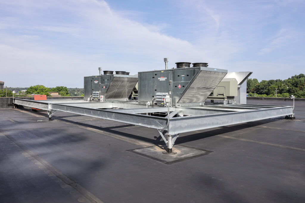 Large HVAC units mounted on a steel frame on a flat commercial roof.