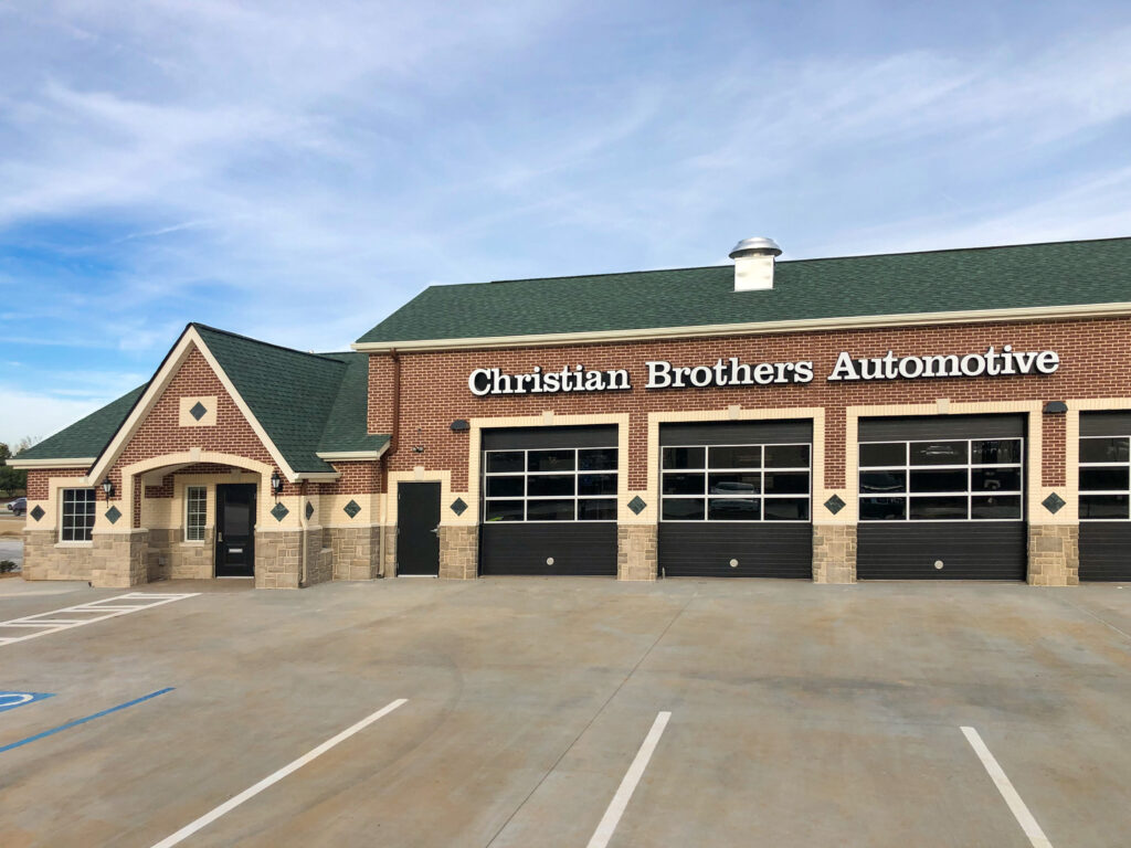 Christian Brothers Automotive repair shop with brick exterior and four garage bays in front of an empty parking lot.
