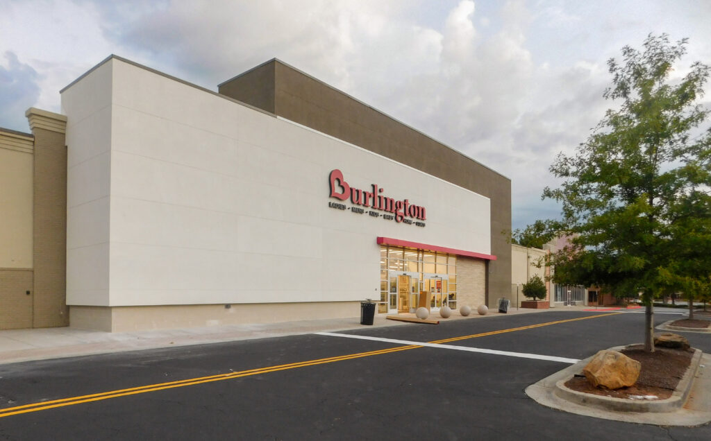 Exterior of a Burlington store with a large sign above the entrance, seen from an adjacent parking lot.