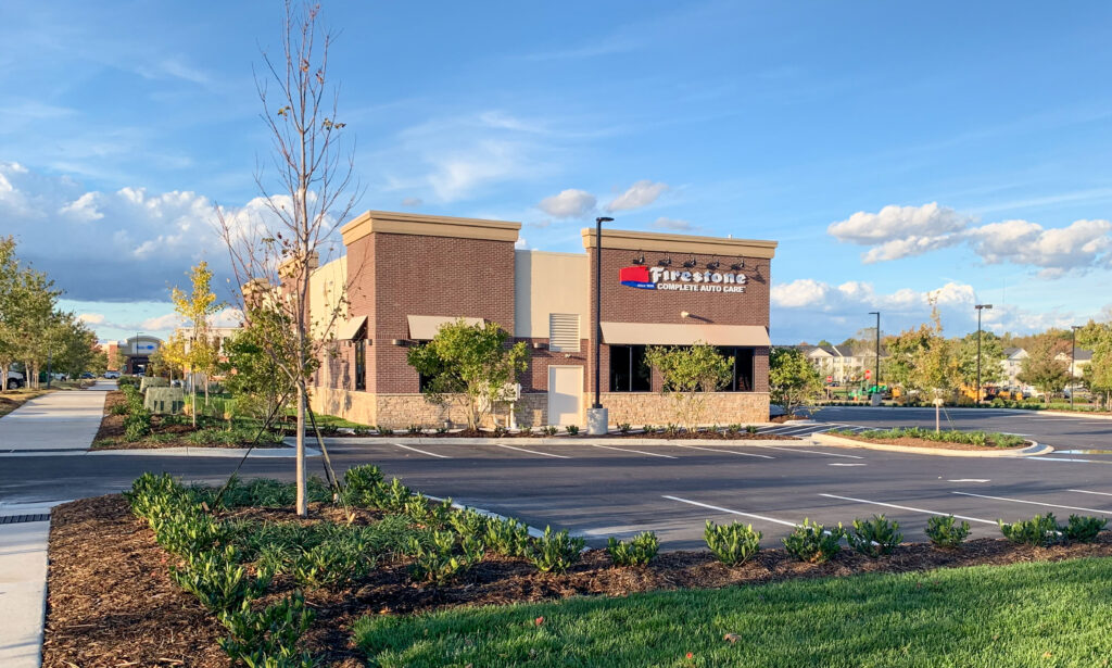 A Firestone Complete Auto Care building with a brick facade and adjacent parking lot.