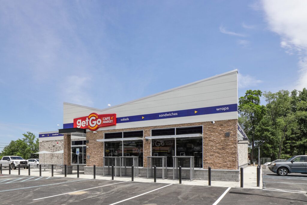 Exterior of a GetGo Cafe + Market with a brick facade, featuring signage for salads, sandwiches, and wraps.