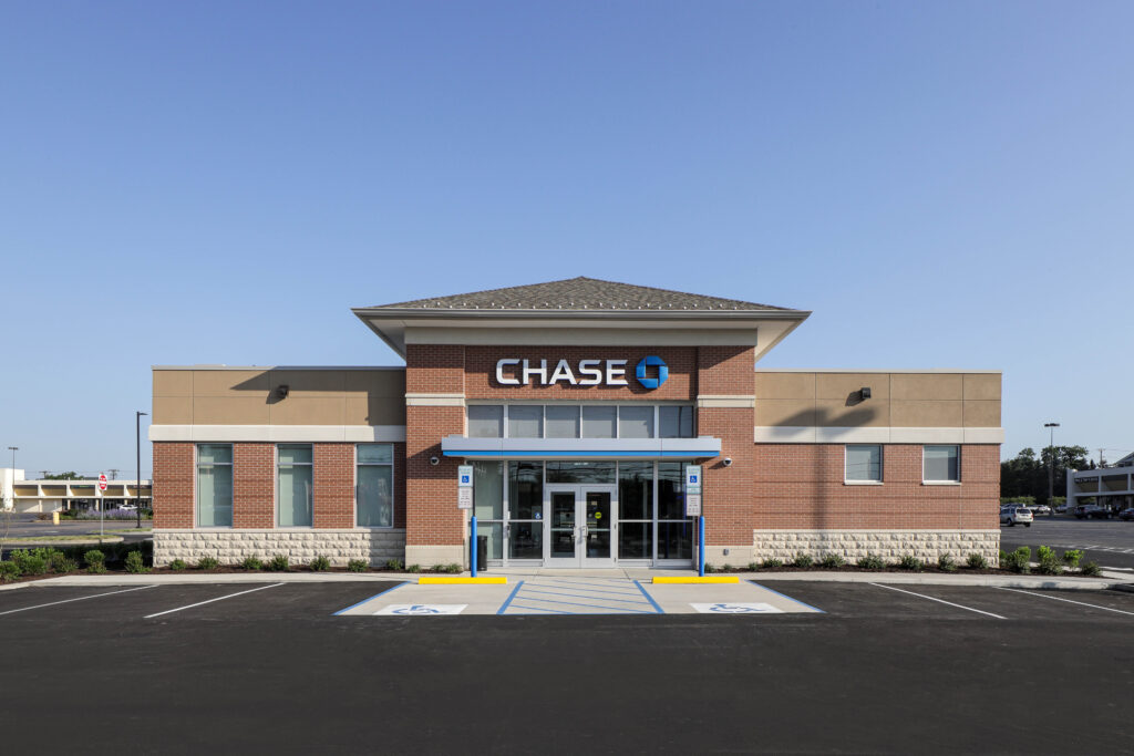 Exterior of a Chase bank branch featuring a brick facade and a large parking lot.