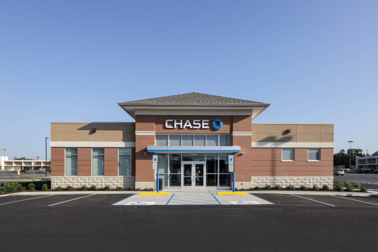 Exterior of a Chase bank branch featuring a brick facade and a large parking lot.