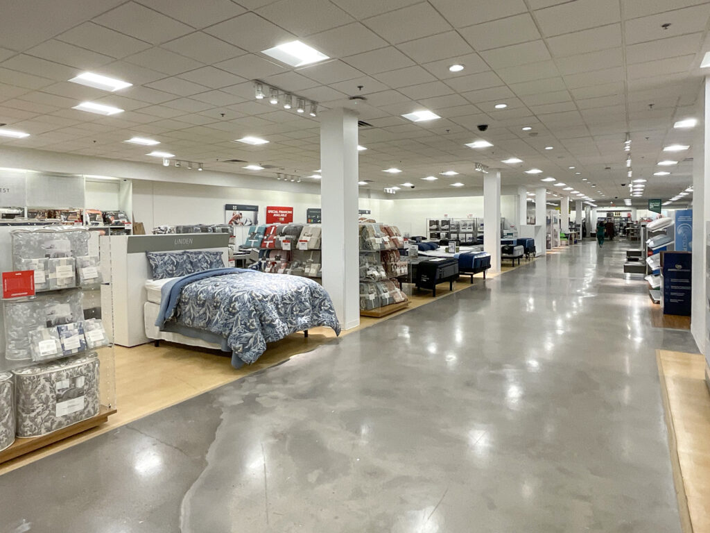A retail showroom floor featuring displays of bed sets and mattresses.