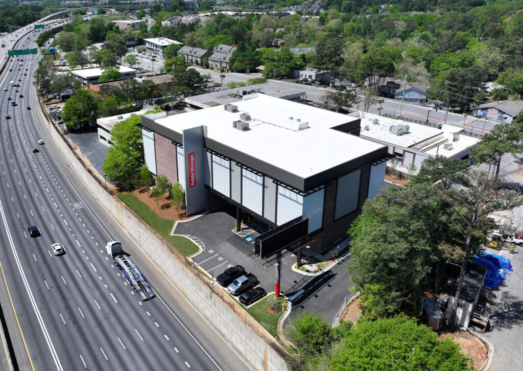 Aerial view of a Public Storage facility located next to a multi-lane highway.