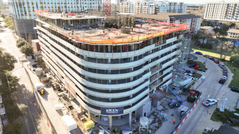 Aerial view of a multi-story parking garage under construction with a Rycon Construction sign on the exterior.