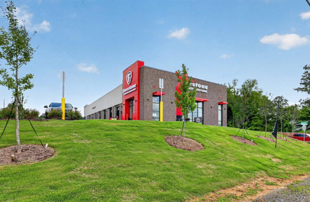 Firestone Complete Auto Care building on a grassy hill.