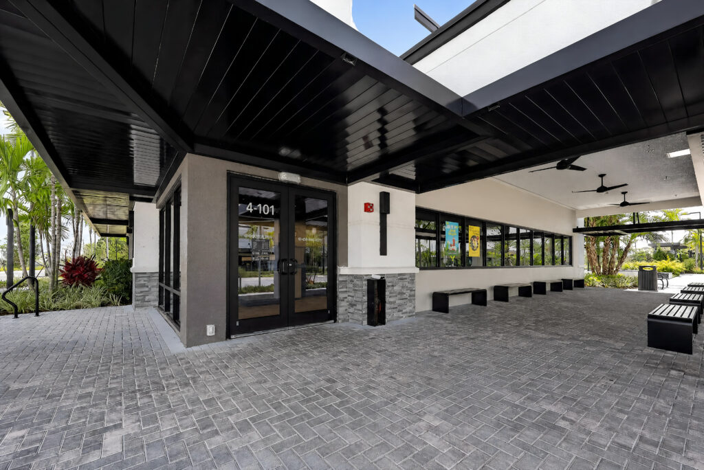 Entrance to suite 4-101 with a covered walkway, glass doors, and outdoor benches.