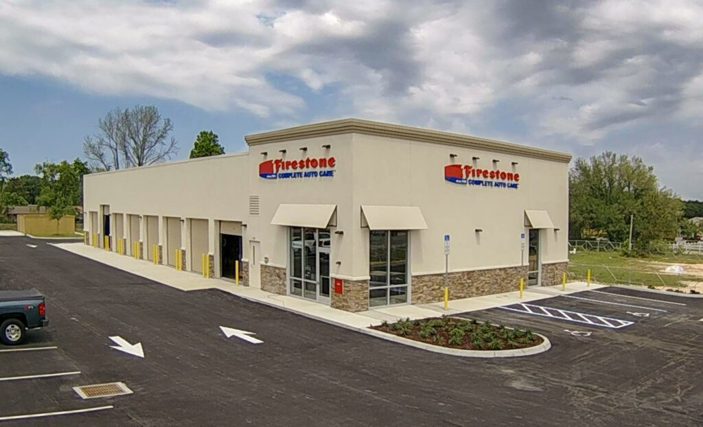 A Firestone Complete Auto Care center building with service bays and a parking lot.