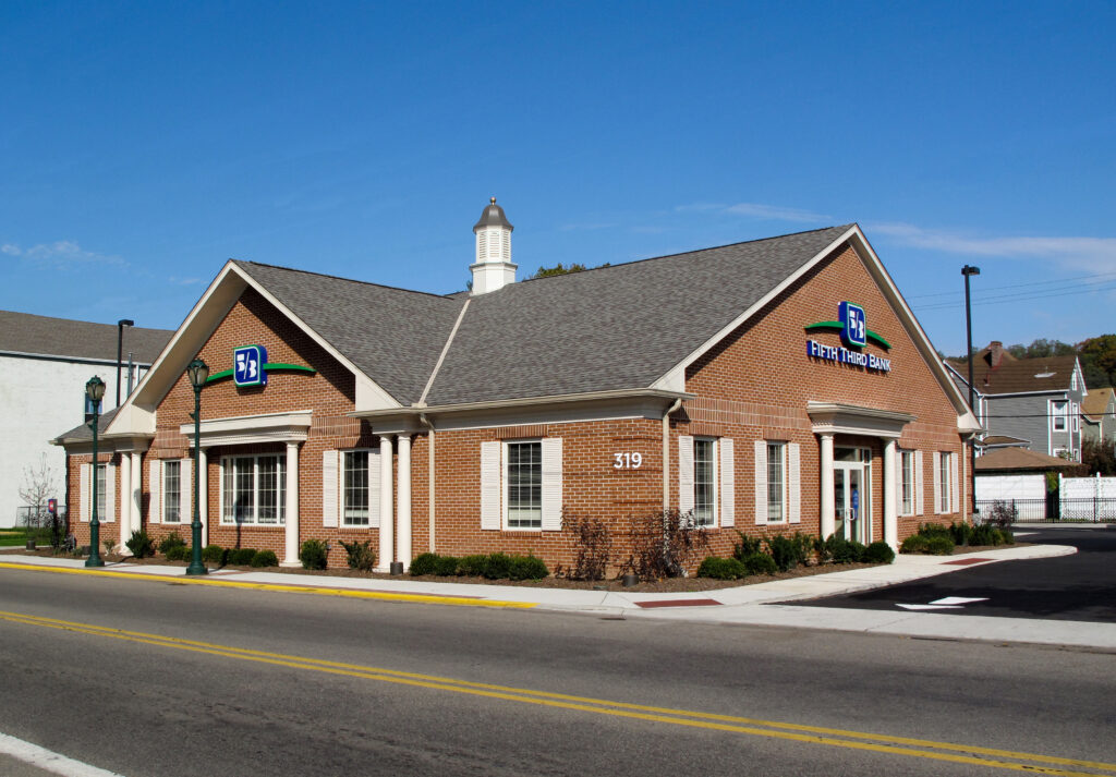 A brick Fifth Third Bank building with white trim and a cupola on a sunny day.