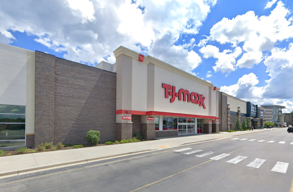 Storefront for a T.J. Maxx retail store with a sidewalk and parking lot in front.