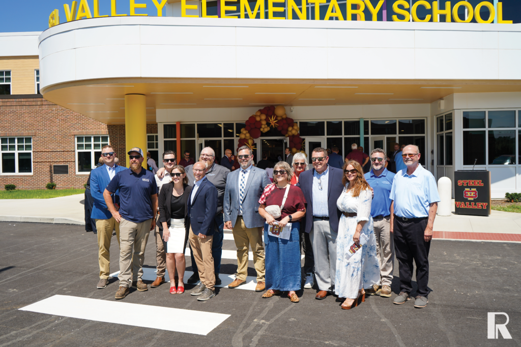 A group of people standing in front of the entrance to Steel Valley Elementary School.