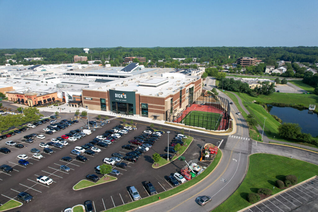 Aerial view of a Dick’s House of Sport store with an adjacent outdoor turf field and a large parking lot.
