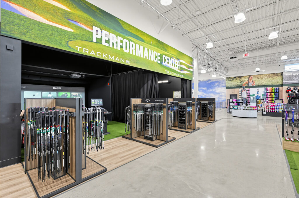 A golf store featuring a Trackman performance center with rows of golf clubs on display.